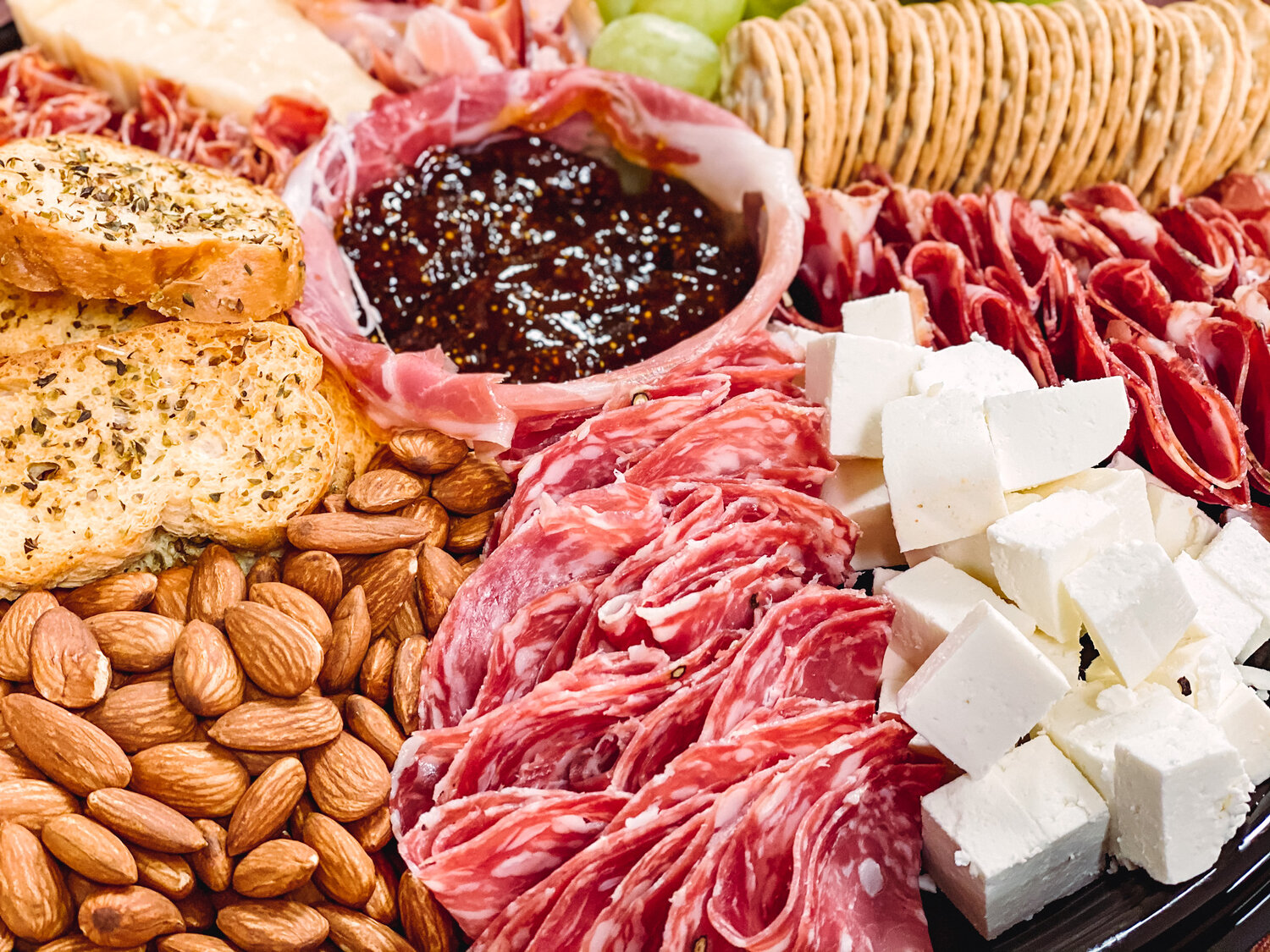 Charcuterie board with meats, cheese, bread, nuts, and more from Livoti's Old World Market