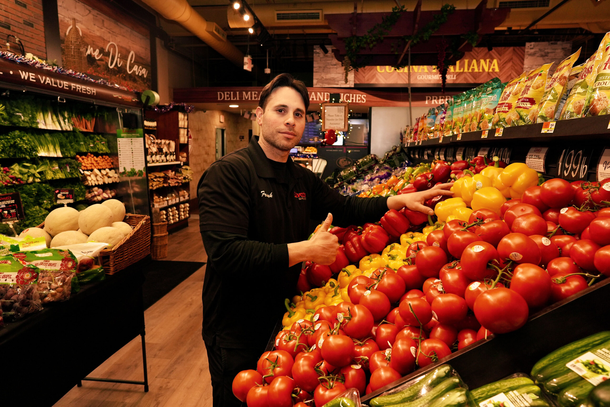 Livoti's Old World Market team member showcasing fresh produce at the store